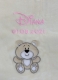 Nahaufnahme einer beigen Babydecke mit Stickerei: Name „Diana“ in rosafarbener Schreibschrift, darunter das Geburtsdatum „01.03.2021“. Unten ist eine beige Teddybär-Applikation mit lächelndem Gesicht und weißen Pfoten.
